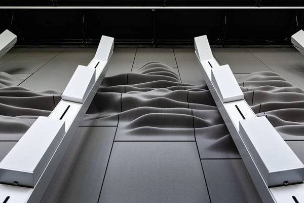 Close-up architectural view of the Immersive Design Lab at ETH Zürich, showcasing custom-engineered white vertical line source loudspeakers designed by Jürgen Strauss, integrated into a precision wave-field synthesis array above a distinctive textured, wave-patterned acoustic floor design.