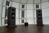 A stereo pair of STRAUSS ELEKTROAKUSTIK SE MF-2.1 Large-Format Passive Monitoring Systems on matching stands, powered by a rack of SE PA-100 power amplifiers inside the dome-shaped SE MUSICLAB research facility.