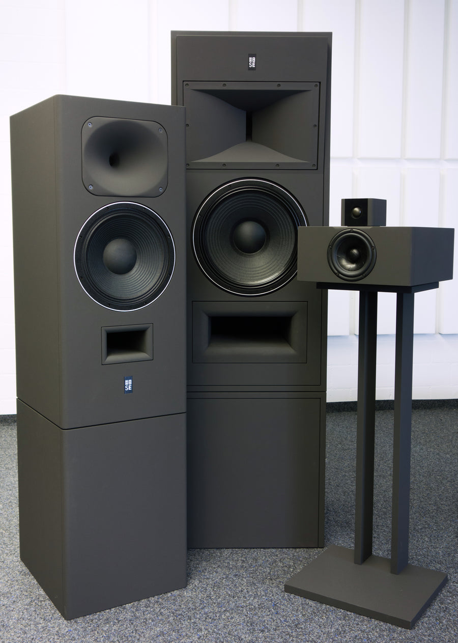 Horizontal wide-angle view of a curated lineup of passive reference monitors from the STRAUSS ELEKTROAKUSTIK collection, showcasing the minimalist, high-end cabinet enclosures and precision acoustic engineering craftsmanship.